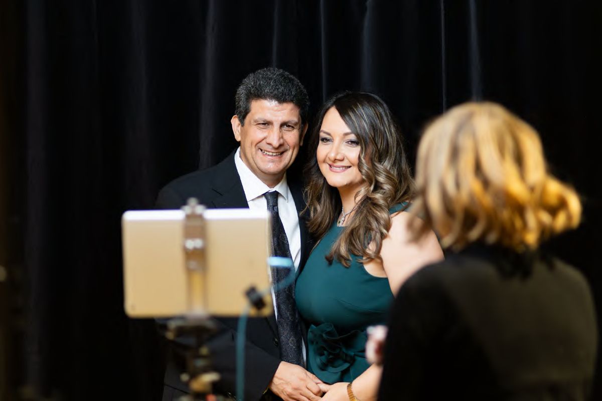 A couple posing at an event photo booth, seen from behind the camera, photographed by Dario Hudon